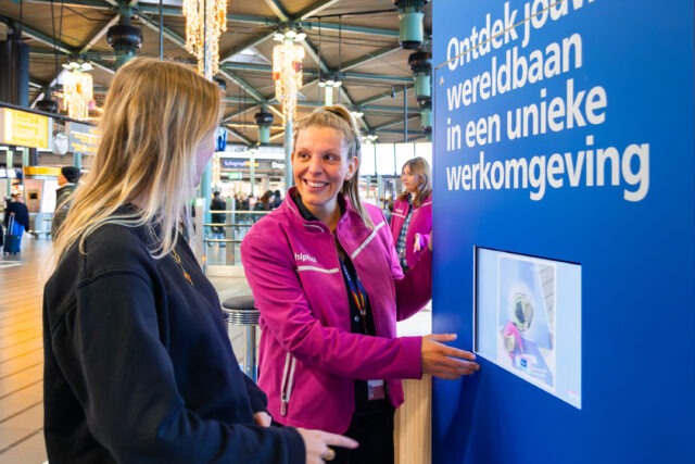 Midden op Schiphol Plaza staat twee weken lang een nieuw 'reisbureau'. Maar geen gewoon reisbureau: de medewerkers kunnen je hier helpen met een nieuwe bestemming in je carrière. Wat wil de luchthaven Schiphol daarmee bereiken?